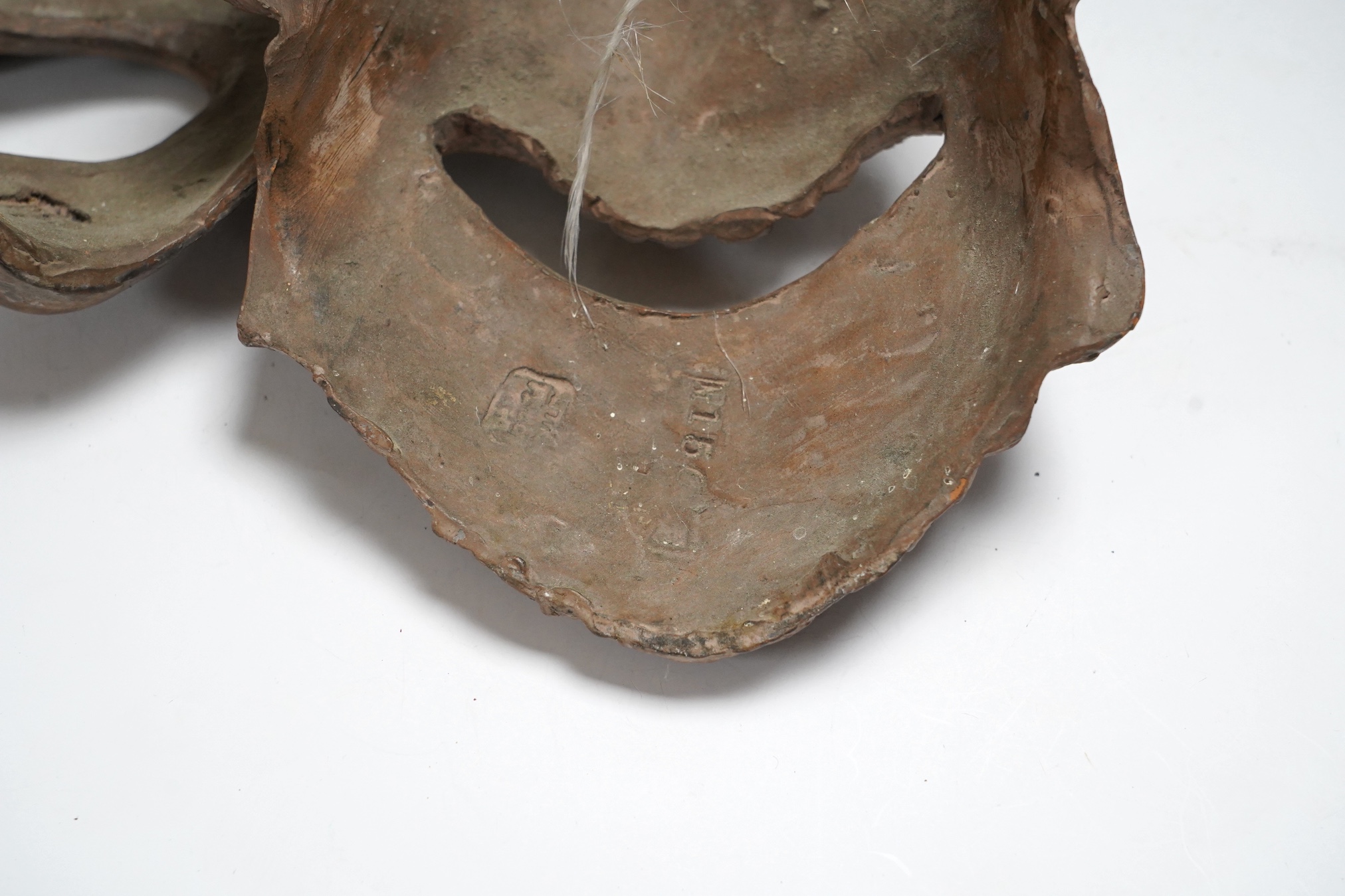 Two pottery face masks, and three pairs of carved and painted masks, largest mask 21cm high